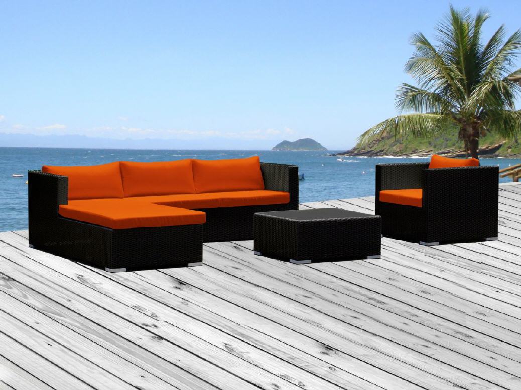 Rattan Lounge mit orangen Kissen